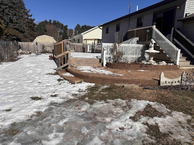 yard layered in snow with fence and a deck