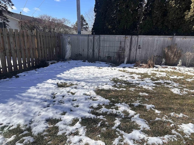 snowy yard featuring fence