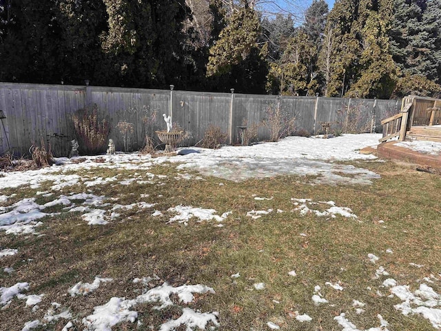 snowy yard with a fenced backyard