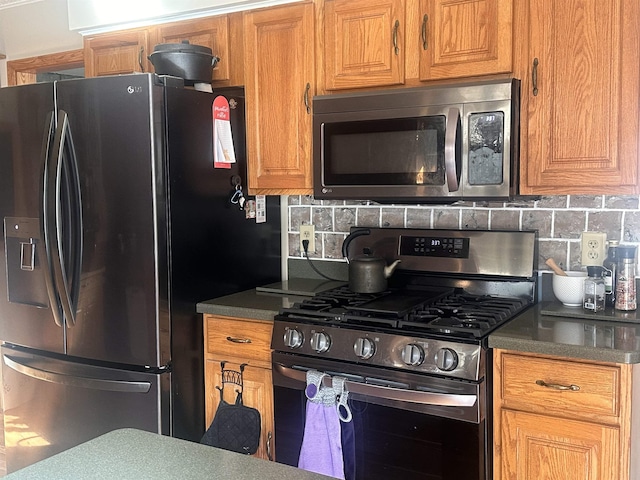 kitchen with brown cabinetry, stainless steel appliances, and backsplash