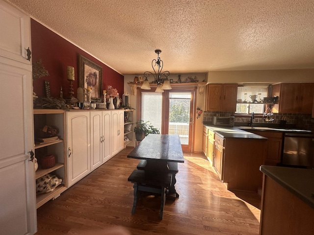 kitchen featuring dark countertops, a sink, a chandelier, and dark wood-style flooring