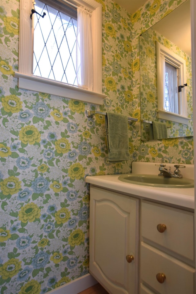 bathroom with vanity and wallpapered walls