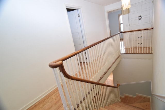 staircase featuring wood finished floors and baseboards