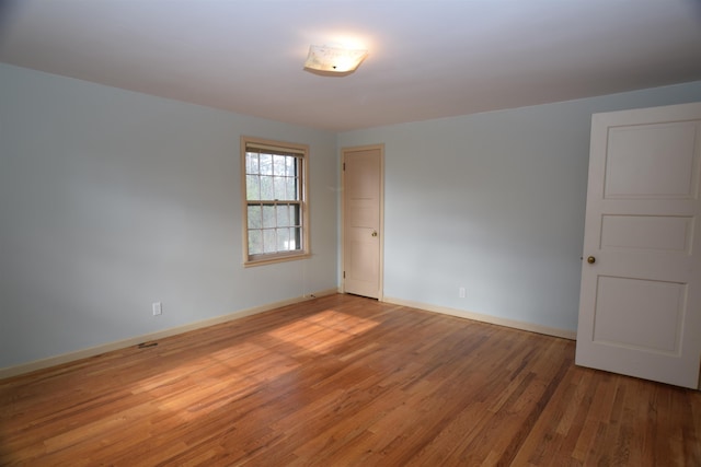 empty room with light wood-style flooring and baseboards