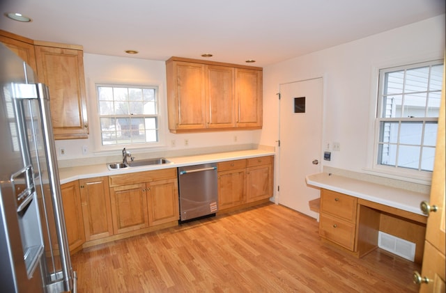 kitchen featuring visible vents, appliances with stainless steel finishes, light countertops, light wood-style floors, and a sink