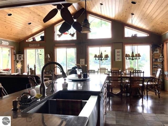 kitchen with ceiling fan with notable chandelier, a sink, and wood ceiling