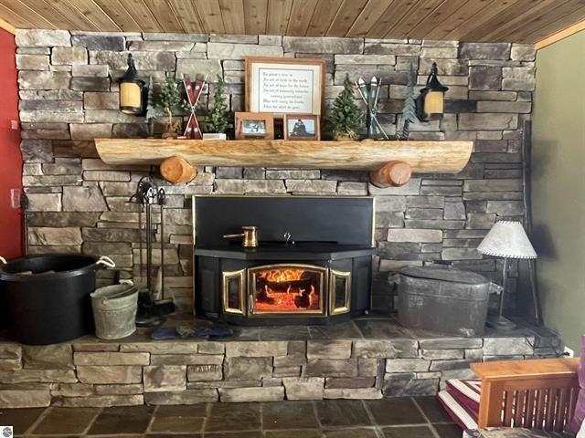 interior details featuring a wood stove and wood ceiling