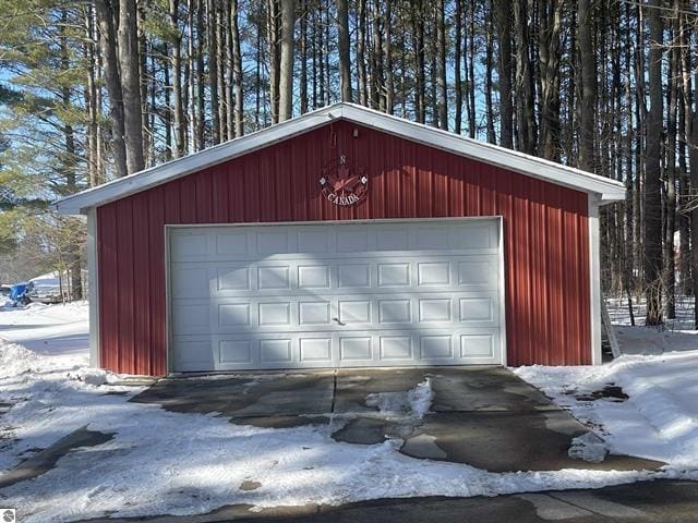 snow covered garage featuring a detached garage