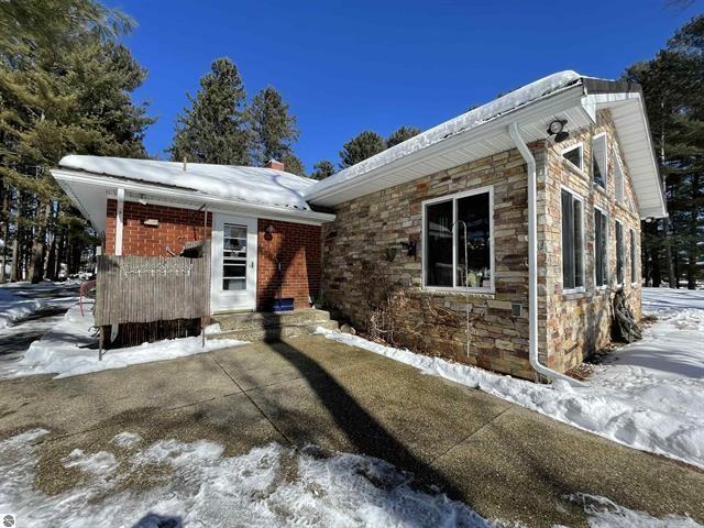 exterior space featuring stone siding and a chimney