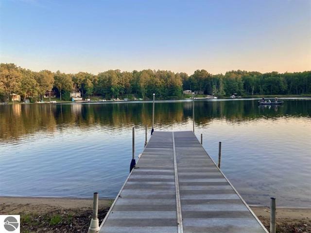 view of dock with a forest view and a water view