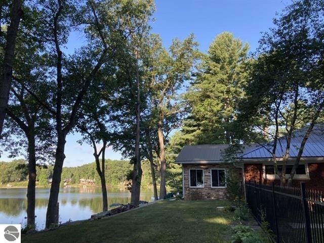 view of yard featuring a water view and fence