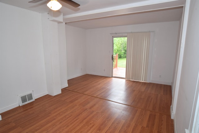 unfurnished room featuring a ceiling fan, baseboards, visible vents, and wood finished floors