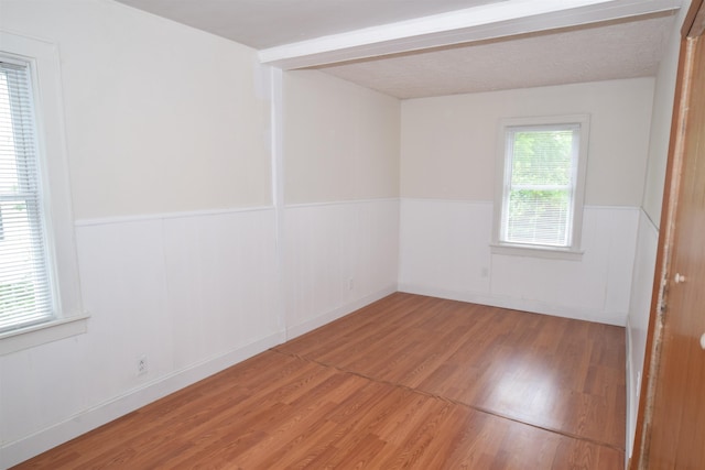 empty room featuring wainscoting and wood finished floors