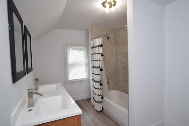 bathroom with shower / bath combination with curtain, lofted ceiling, a sink, and wood finished floors