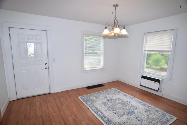 entrance foyer featuring a notable chandelier, wood finished floors, visible vents, and baseboards