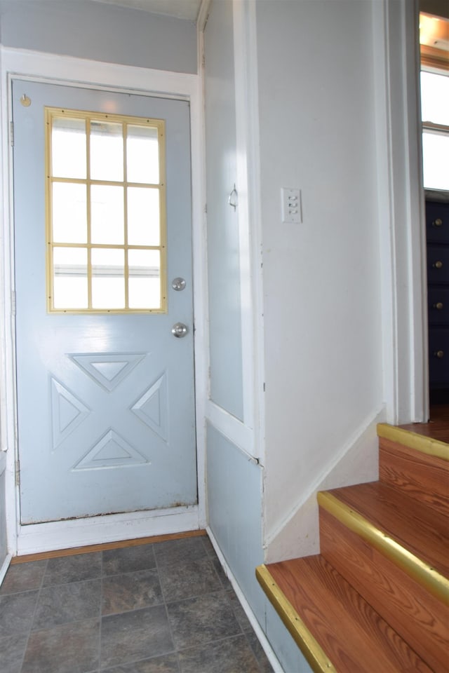 doorway to outside featuring stone finish floor, baseboards, and stairs