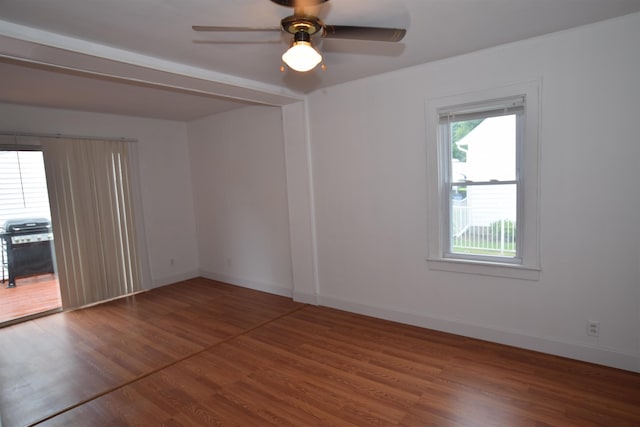 empty room featuring ceiling fan, wood finished floors, and baseboards