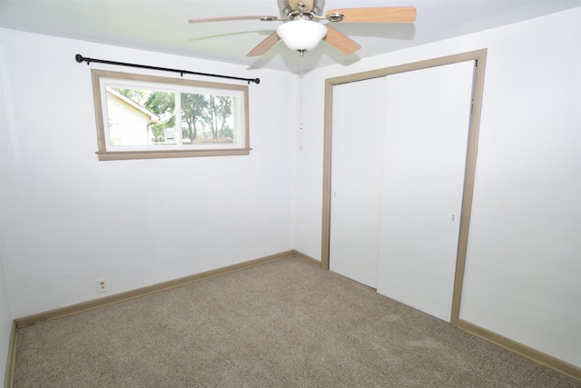 unfurnished bedroom featuring a ceiling fan, a closet, carpet flooring, and baseboards