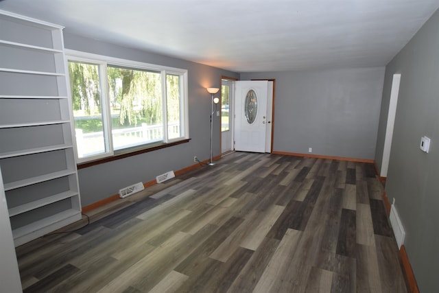 foyer entrance featuring visible vents, baseboards, and wood finished floors