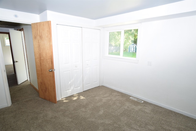 unfurnished bedroom featuring baseboards, carpet, visible vents, and a closet