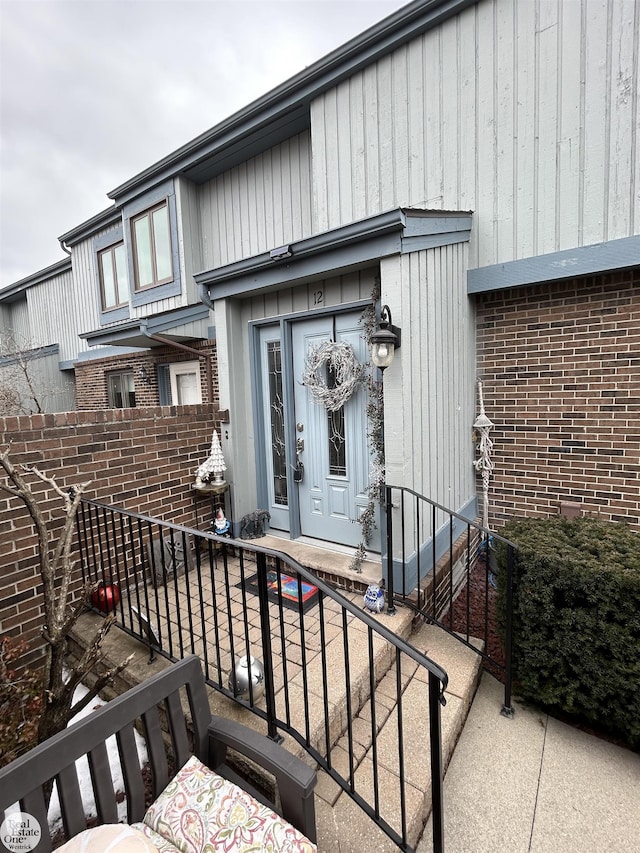 view of exterior entry featuring brick siding