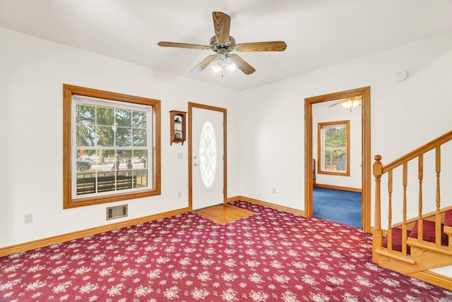 foyer entrance with stairway, carpet, visible vents, and baseboards