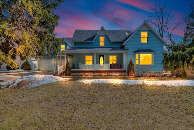 view of front of house with a porch, a front yard, roof with shingles, and an attached garage