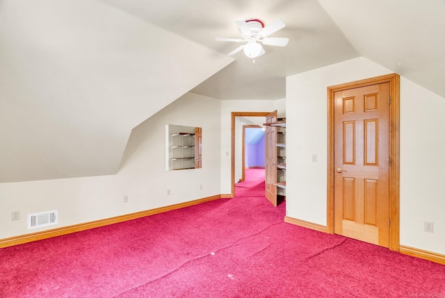 additional living space with carpet, visible vents, a ceiling fan, vaulted ceiling, and baseboards