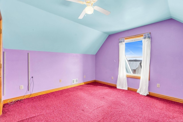 additional living space featuring carpet floors, a ceiling fan, visible vents, vaulted ceiling, and baseboards