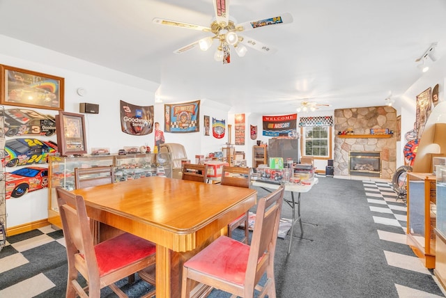 dining room with ceiling fan, carpet floors, a fireplace, and track lighting