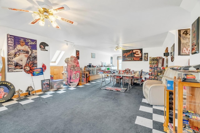 interior space with track lighting, vaulted ceiling, and a ceiling fan