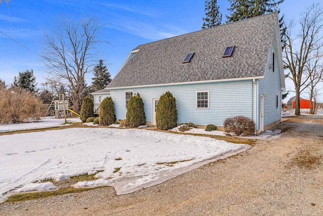 view of property exterior with driveway and roof with shingles