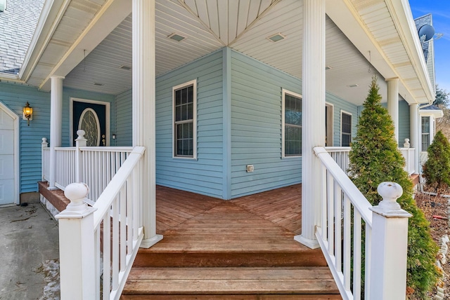 entrance to property featuring a porch and a shingled roof