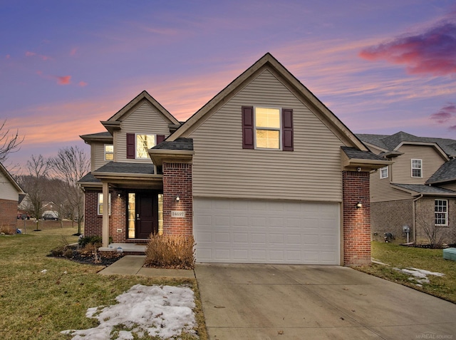 traditional-style home featuring a garage, a front yard, concrete driveway, and brick siding