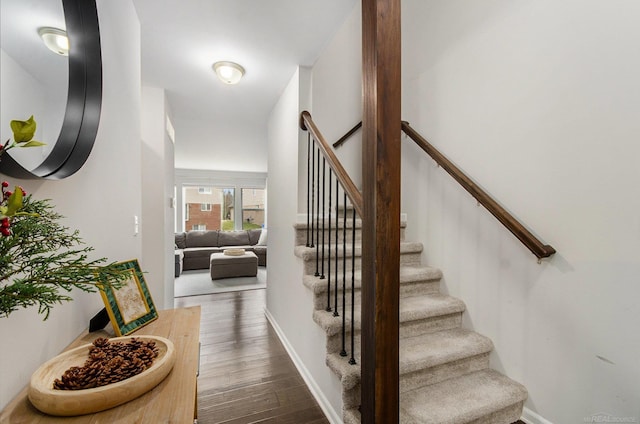 foyer entrance with stairs, baseboards, and wood finished floors