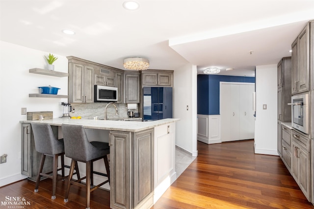 kitchen with a peninsula, fridge with ice dispenser, open shelves, and dark wood finished floors