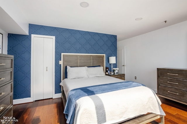 bedroom featuring baseboards, wood finished floors, and wallpapered walls