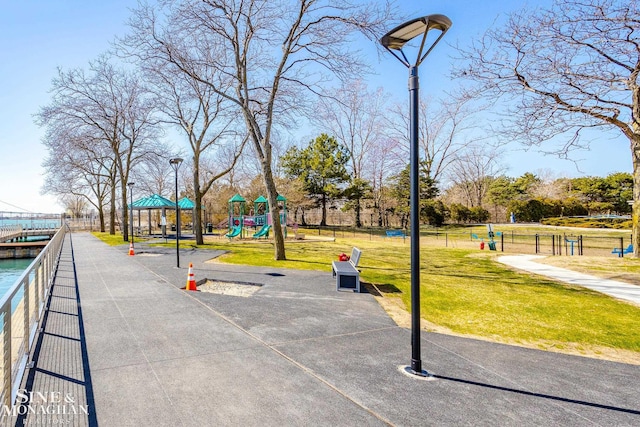 view of home's community featuring playground community and a lawn