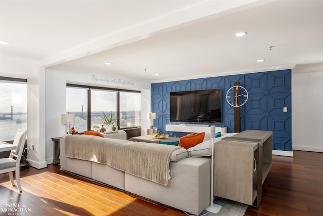 living area with an accent wall, recessed lighting, dark wood finished floors, and baseboards