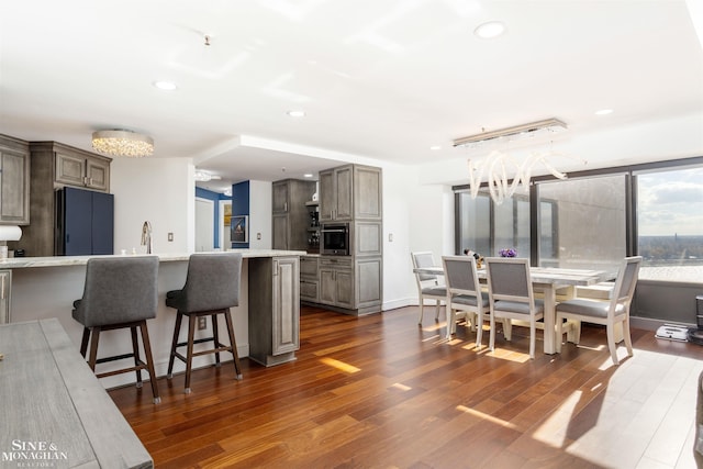 kitchen featuring light countertops, dark wood-type flooring, and a kitchen bar