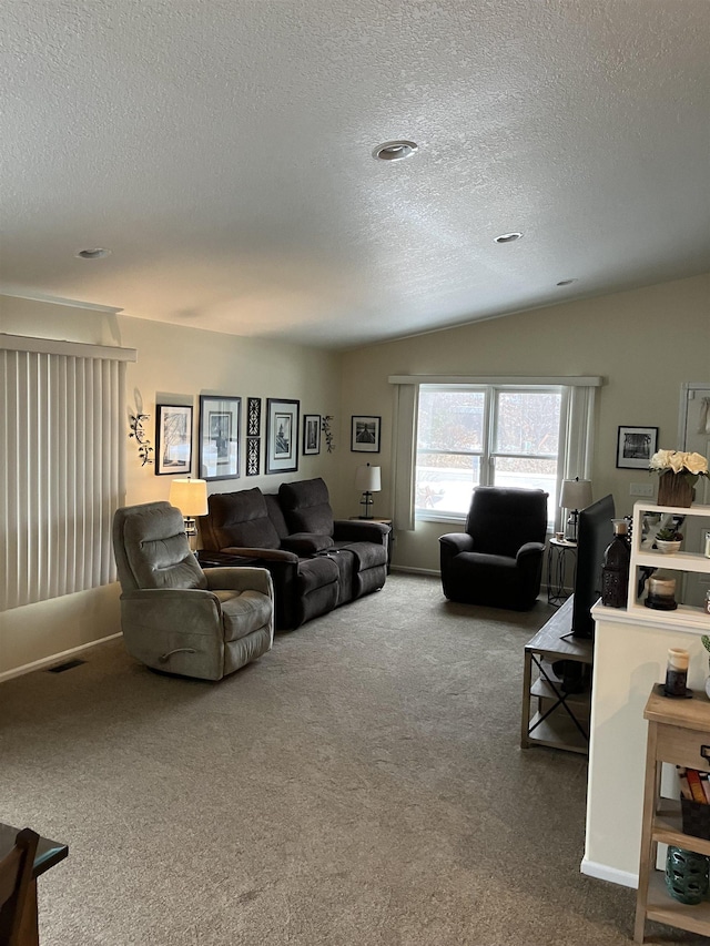 carpeted living room with visible vents, vaulted ceiling, and a textured ceiling