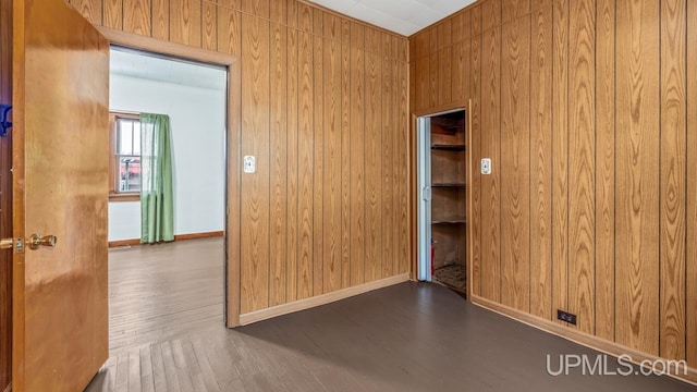 spare room featuring wooden walls and wood finished floors