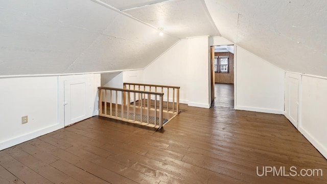 bonus room with lofted ceiling, hardwood / wood-style floors, and baseboards