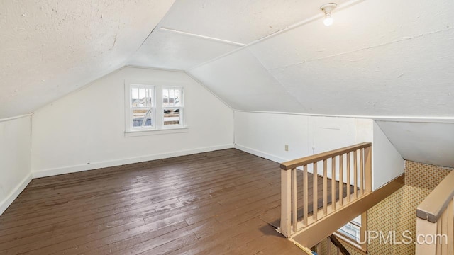 bonus room with lofted ceiling, baseboards, a textured ceiling, and hardwood / wood-style floors