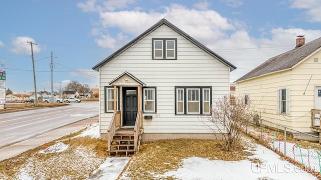 bungalow-style home with entry steps and fence