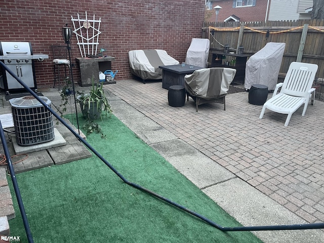 view of patio featuring central AC unit, fence, and area for grilling