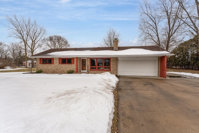 single story home with concrete driveway, brick siding, a chimney, and an attached garage