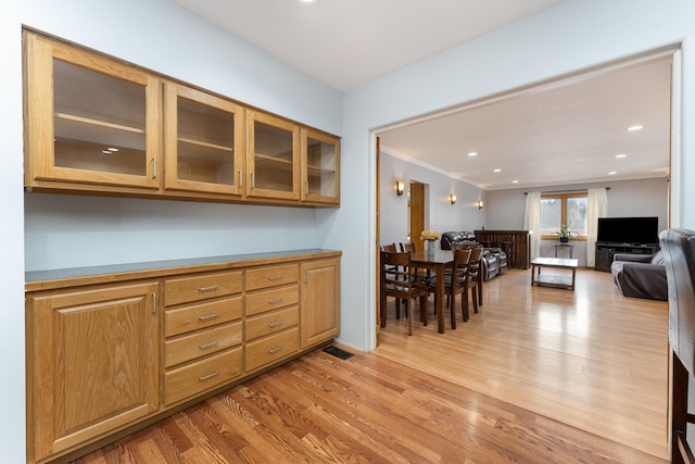 dining room with light wood-type flooring, visible vents, crown molding, and recessed lighting