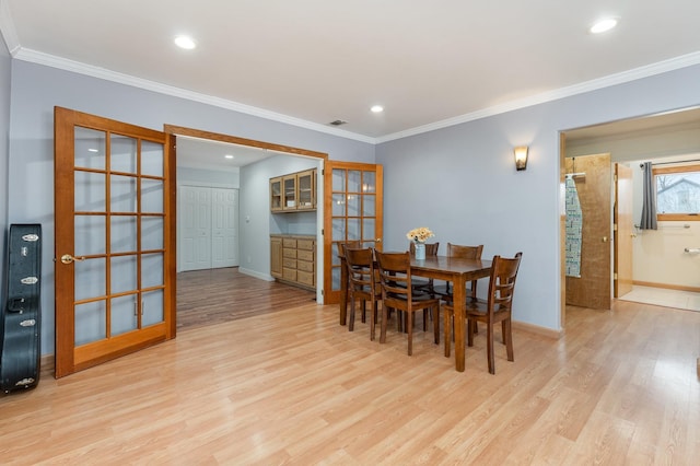 dining space featuring crown molding, recessed lighting, light wood-type flooring, and baseboards