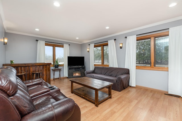 living area featuring light wood-type flooring, baseboards, crown molding, and recessed lighting